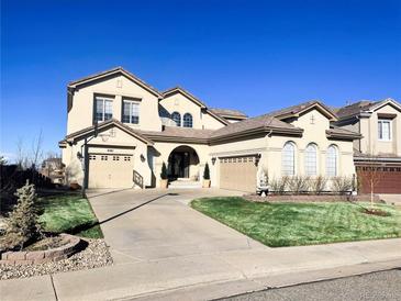 Charming home featuring a well-manicured lawn, driveway and a three-car garage at 6561 Ocaso Dr, Castle Pines, CO 80108
