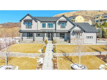 Two-story farmhouse-style home with stone accents and landscaped yard at 359 Castlemaine Ct, Castle Rock, CO 80104