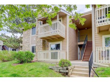 Inviting condo with stone and siding exterior, plus a charming balcony and well-maintained landscaping at 4400 S Quebec St # 105K, Denver, CO 80237
