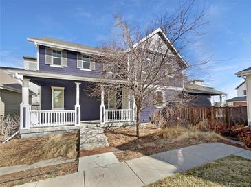 Charming two-story home with a welcoming front porch and manicured landscaping at 4940 Akron St, Denver, CO 80238