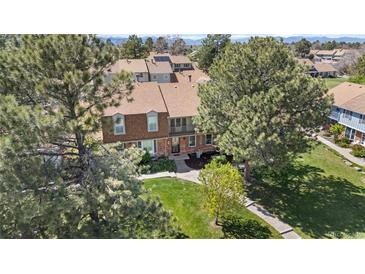 Charming brick townhome with a second-story balcony surrounded by mature trees at 7355 S Knolls Way, Centennial, CO 80122