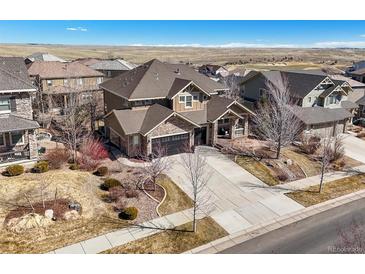 Beautiful two-story home with a landscaped front yard and a long driveway on a sunny day at 7680 S Blackstone Pkwy, Aurora, CO 80016