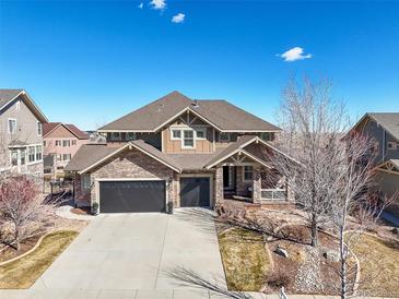 Charming two-story home with stone accents, attached garage, and a well-manicured front yard at 7680 S Blackstone Pkwy, Aurora, CO 80016