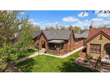 Charming brick home with a well-manicured lawn and inviting front porch, perfect for relaxing on summer evenings at 1840 S Grant St, Denver, CO 80210