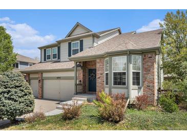 Charming two-story home boasts a brick facade, bay window, and well-manicured landscaping at 6092 S Ouray St, Aurora, CO 80016