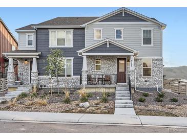 Attractive two-story home featuring a stone-accented facade, covered porch, and manicured front yard at 9786 Rosalee Peak St, Littleton, CO 80125