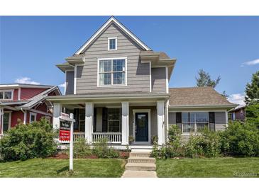 Charming gray two-story home featuring a welcoming front porch and manicured lawn at 3354 Wabash St, Denver, CO 80238