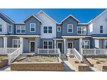 Charming townhouse featuring light blue siding and a well-manicured front yard at 1974 S Haleyville Way, Aurora, CO 80018