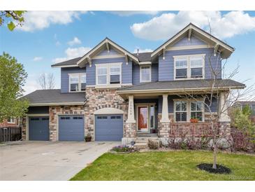 Charming two-story home with a covered porch, three-car garage, and meticulously maintained front lawn at 26404 E Caley Dr, Aurora, CO 80016
