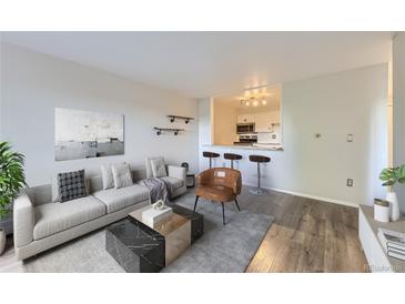 Bright living room featuring contemporary decor, hardwood floors, and an opening to the kitchen at 1008 N Corona St # 403, Denver, CO 80218