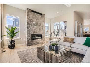 Bright living room with fireplace, light wood floors and large windows at 1764 Peak Loop, Broomfield, CO 80023