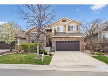 Charming two-story home boasts a brick facade, well-maintained lawn, and attached two-car garage at 22560 E Rowland Dr, Aurora, CO 80016