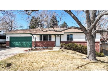 Charming single-story home featuring a green garage door, brick accents, and a well-maintained front yard at 7559 Jay Ct, Arvada, CO 80003