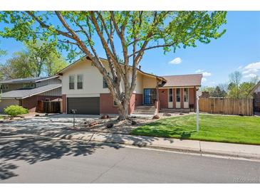 Charming two-story home with brick accents, attached garage, a mature tree, and well-maintained lawn at 3832 S Quebec St, Denver, CO 80237