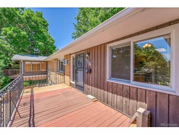 Inviting front porch with wood floors, perfect for relaxing outdoors in this charming home at 2682 S Benton St, Lakewood, CO 80227