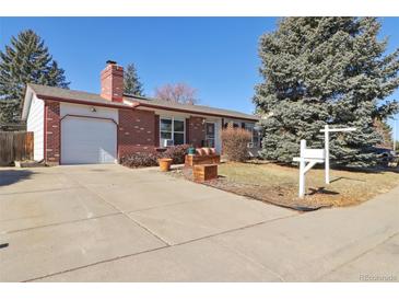 Charming brick home featuring a spacious driveway, attached garage, and well-maintained front yard at 1755 S Yampa Way, Aurora, CO 80017