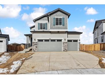 Two-story house with gray siding, three-car garage, and landscaping at 17751 E 93Rd Ave, Commerce City, CO 80022