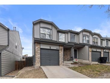 Charming gray two-story townhouse featuring a one-car garage and stone accents at 2005 E 103Rd Ave, Thornton, CO 80229