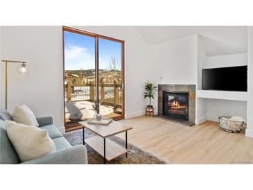 Bright living room with a fireplace and deck access with mountain views at 34 Highfield Trl # 307, Breckenridge, CO 80424