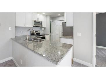 Bright kitchen features gray granite countertops, subway tile backsplash, and stainless steel appliances at 4076 S Carson St # H, Aurora, CO 80014