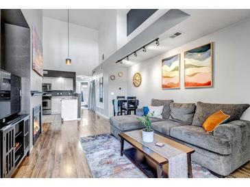 Open-concept living space with high ceilings, modern lighting, and stylish decor at 2541 S Bahama Cir # E, Aurora, CO 80013