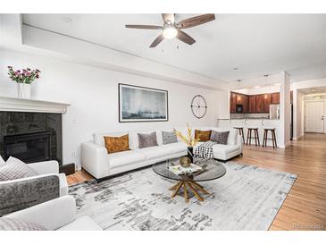 Bright living room features modern decor, fireplace, hardwood floors, and an open floor plan at 1699 N Downing St # 302, Denver, CO 80218