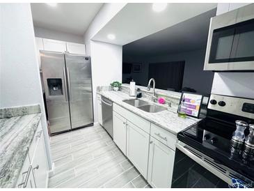 This kitchen features stone countertops, stainless steel appliances and tiled floors at 12223 E Ford # 12223, Aurora, CO 80012