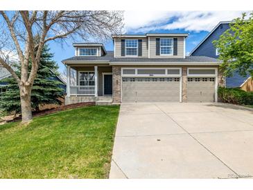 Charming two-story home features a large driveway and an attached three car garage at 1041 Riddlewood Rd, Highlands Ranch, CO 80129