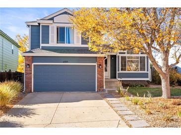 Inviting two-story home featuring a blue exterior, brick accents, well-kept lawn, and a spacious two-car garage at 11525 Eaton Ct, Westminster, CO 80020