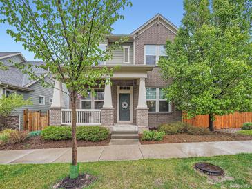 Charming two-story brick home with a covered front porch, well-maintained landscaping, and mature trees in a suburban neighborhood at 5535 W 96Th Pl, Westminster, CO 80020