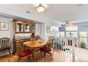 Bright dining room featuring hardwood floors, a wooden table, and view to living area at 8199 Welby Rd # 3102, Denver, CO 80229