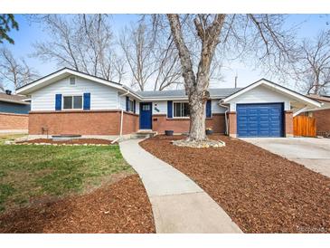 Charming brick home with blue accents, a mature tree, and inviting curb appeal at 9395 W Kentucky Ave, Lakewood, CO 80226