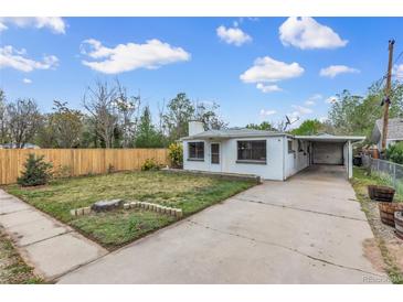 Charming single-story home with a well-maintained front yard, a carport and a newly constructed wooden fence at 7760 Magnolia St, Commerce City, CO 80022