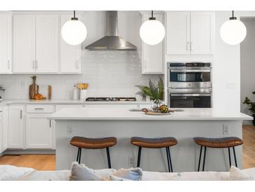 Modern kitchen with white cabinets, stainless steel appliances, and quartz countertops at 3589 Rucksack Ct, Castle Rock, CO 80108