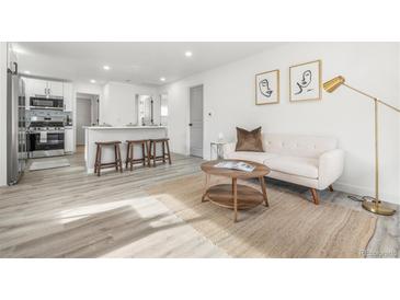 Bright living room with modern decor, including a sofa, round tables, and stylish artwork at 3311 Jasmine St, Denver, CO 80207