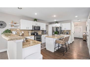 Bright kitchen boasts granite counters, stainless steel appliances, and a charming breakfast bar with seating at 13340 Saint Paul St, Thornton, CO 80241