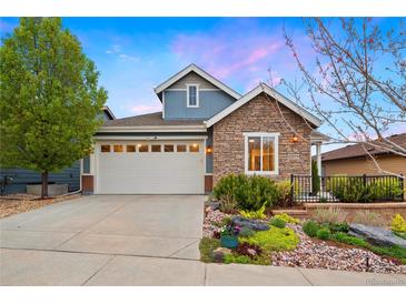 Charming two-story home featuring stone accents, a two-car garage, and a well-maintained front yard with landscaping at 12575 Sandstone Dr, Broomfield, CO 80021