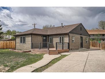 Charming single-story home featuring a welcoming front porch, landscaped yard, and private driveway at 6000 Yarrow St, Arvada, CO 80004