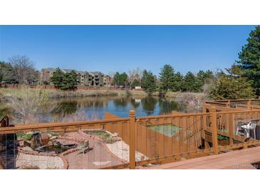 A beautiful pond-side view showcases mature trees and landscaping from the outdoor deck at 163 Ward Ct, Lakewood, CO 80228