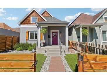 Charming home featuring a vibrant door, landscaped front yard, and inviting curb appeal at 3207 N Marion St, Denver, CO 80205