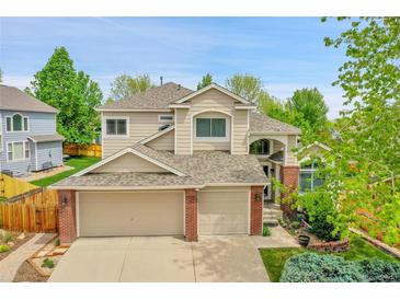 Charming two-story home featuring a three car garage, brick accents and a well maintained lawn at 10653 W Parkhill Dr, Littleton, CO 80127