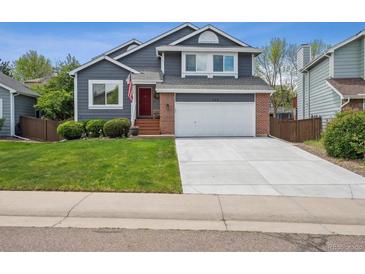 Charming two-story home with a well-maintained lawn and a two-car garage, showcasing curb appeal at 748 Poppywood Pl, Highlands Ranch, CO 80126