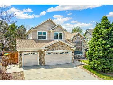 Charming two-story home with stone accents, a three-car garage, and a well-manicured front lawn at 627 Millbrook Cir, Castle Rock, CO 80109