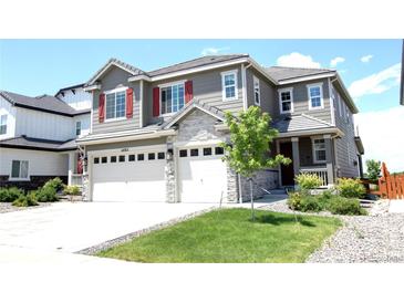 Charming two-story home featuring a three-car garage, red shutters, stone accents and a well-manicured front yard at 14763 Pepper Pike Pl, Parker, CO 80134