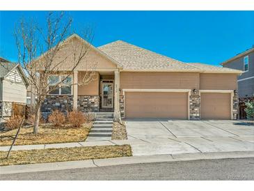 Charming single-Gathering home with a three-car garage and stone veneer accents on a sunny day at 6434 N Ensenada Ct, Aurora, CO 80019