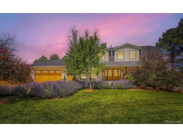 Charming two-story home with a well-manicured lawn and beautiful landscaping and a sunset in the background at 6709 Walker Ct, Niwot, CO 80503