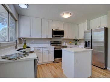 Bright kitchen with white cabinetry, stainless steel appliances, and a convenient center island at 13382 Franklin St, Thornton, CO 80241