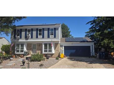 Charming two-story home with blue shutters, solar panels, brick accents and manicured front yard at 1024 S Mobile St, Aurora, CO 80017