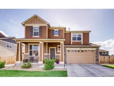 Charming two-story home featuring stone accents, a covered porch, and a two-car garage at 353 Zuniga St, Brighton, CO 80601