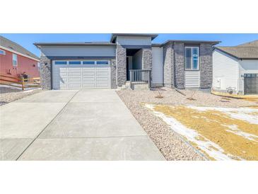 Charming exterior showing stone accents, a concrete driveway, and a two-car garage at 39555 Gwinett Cir, Elizabeth, CO 80107